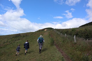 A group of people walking up the hill to Golden Cap